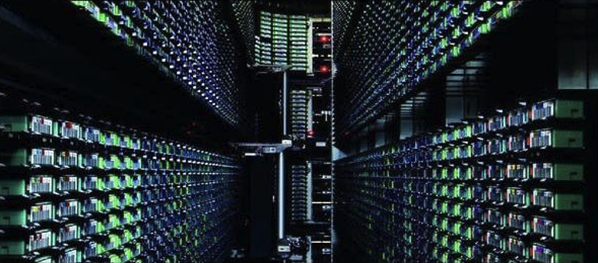 Corredor de um data center com inúmeras unidades de armazenamento organizadas em racks, iluminado por luzes de operação em tons verdes e azuis.